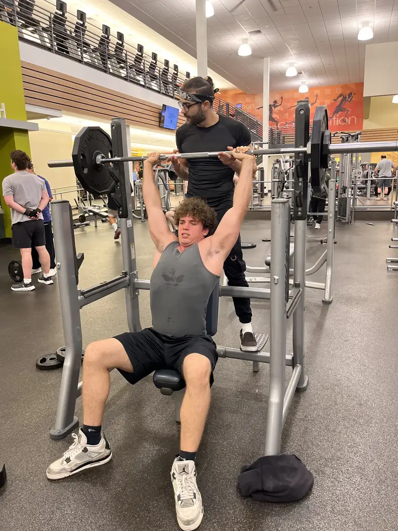 A client completing a coached gym press with Haiko