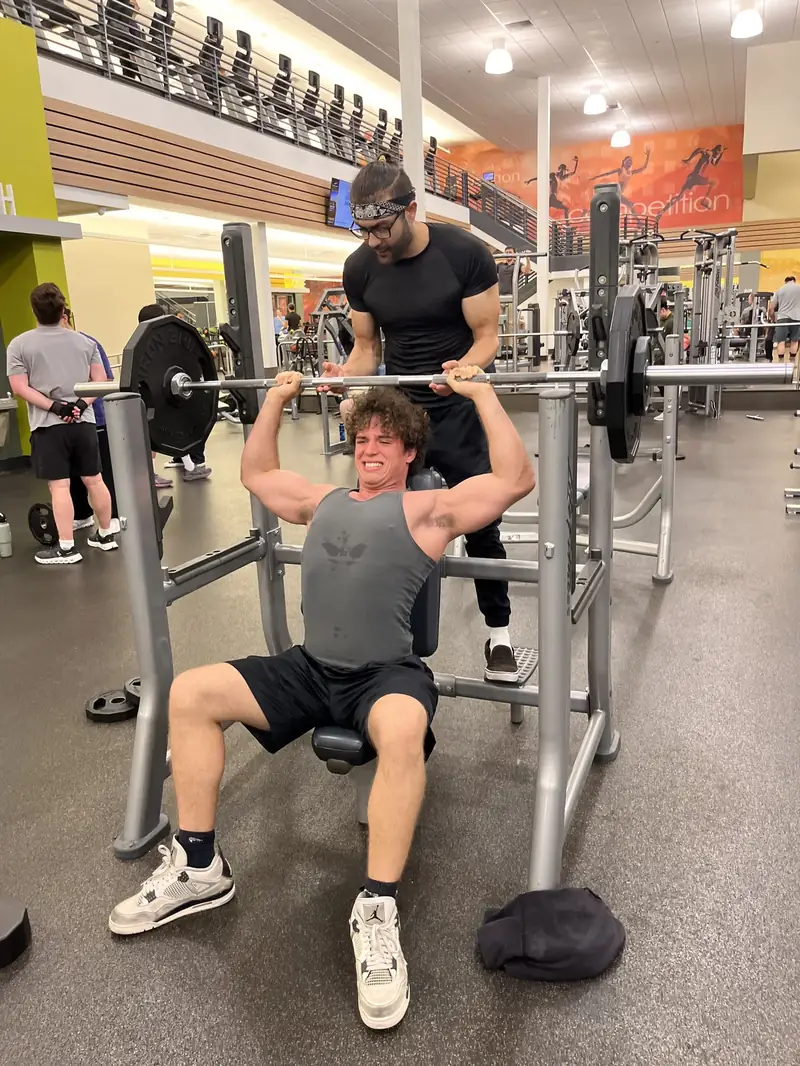 Haiko coaching a client's exercise form in a gym